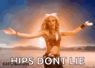 A Woman Is Standing In The Desert With Her Arms Outstretched And Says Hips Dont Lie GIF