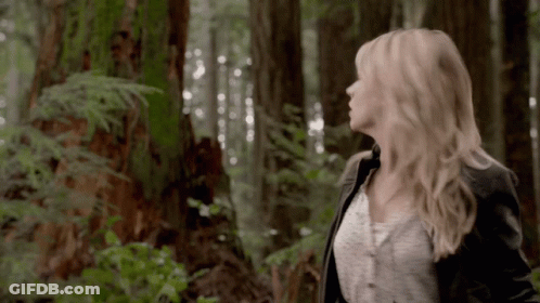 Woman Standing In Forest Looking Up At Sky GIF