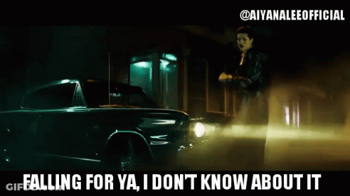 A Woman Is Standing Next To A Car That Says " Falling For Ya I Don 'T Know About It " GIF