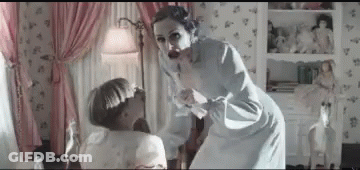 A Woman Is Standing Next To A Little Girl In A Room . GIF
