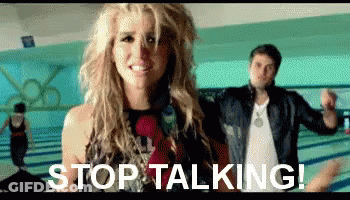 A Woman Is Standing Next To A Man In A Bowling Alley With The Words `` Stop Talking '' Written On The Screen . GIF
