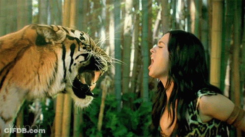 A Woman Is Standing Next To A Tiger With Yahoo Written On The Bottom Right GIF