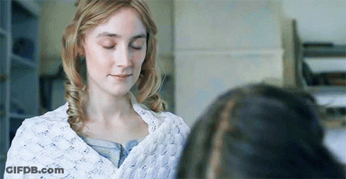 A Woman Is Standing Next To Another Woman With Her Eyes Closed And A White Blanket On Her Shoulders . GIF