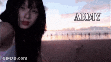 A Woman Is Standing On A Beach With The Word Army Behind Her GIF