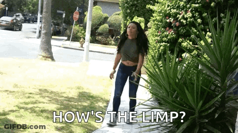 A Woman Is Standing On A Sidewalk With The Words `` How 'S The Limp '' Written Above Her . GIF