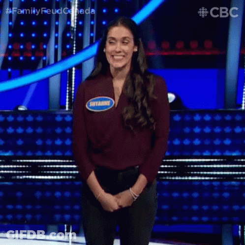 A Woman Is Standing On A Stage With Her Hands Folded And A Name Tag That Says Shyanne . GIF