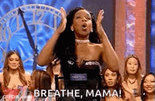 A Woman Is Standing On A Stage With Her Hands In The Air And A Group Of Women Behind Her . GIF