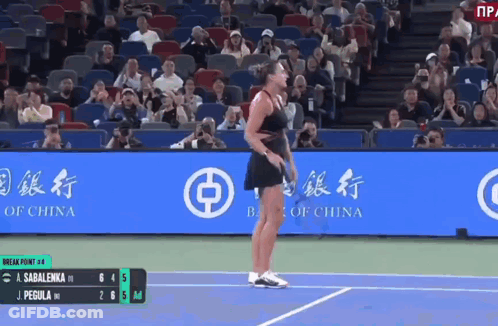 A Woman Is Standing On A Tennis Court In Front Of A Bank Of China Banner GIF