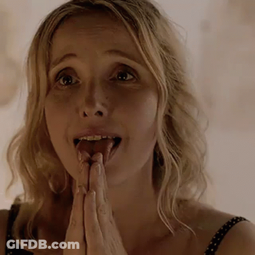 A Woman Is Sticking Her Tongue Out While Praying With Her Hands Together . GIF