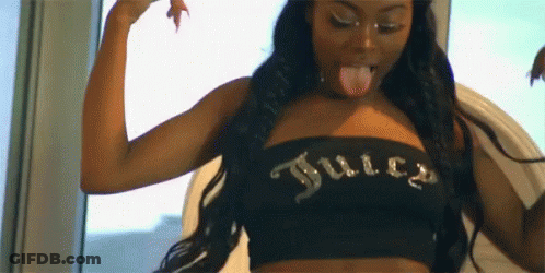 A Woman Is Sticking Her Tongue Out While Wearing A Black Juicy Couture Top . GIF