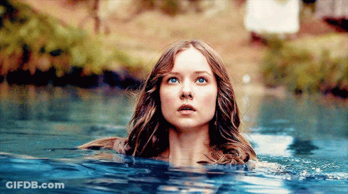 A Woman Is Swimming In A Body Of Water With Her Eyes Closed GIF