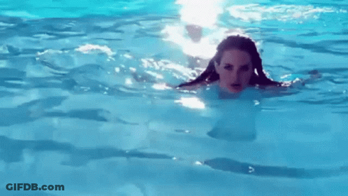 A Woman Is Swimming In A Pool With Her Hair Visible . GIF