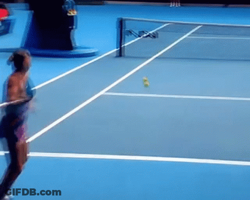 A Woman Is Swinging A Tennis Racket On A Blue Tennis Court . GIF