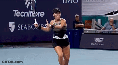 A Woman Is Swinging A Tennis Racquet On A Tennis Court In Front Of A Sign That Says Tecnifibre GIF