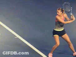 A Woman Is Swinging A Tennis Racquet On A Tennis Court With A Sign That Says Florida GIF