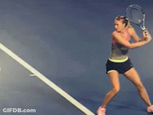 A Woman Is Swinging A Tennis Racquet On A Tennis Court With A Sign That Says Florida GIF
