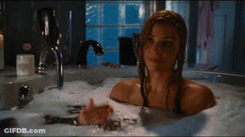 A Woman Is Taking A Bath In A Bubble Bath GIF