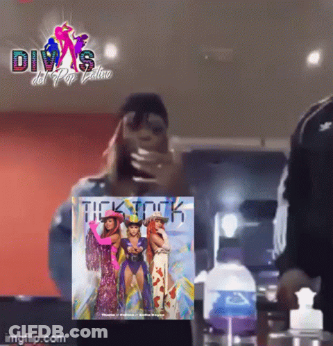 A Woman Is Taking A Picture Of Herself In Front Of A Poster That Says Divas Del Pop Latino GIF