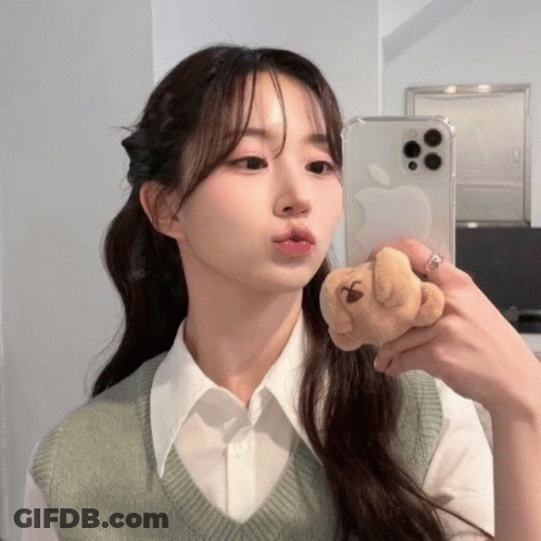 A Woman Is Taking A Picture Of Herself In The Mirror GIF