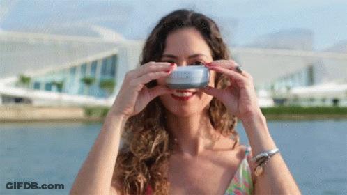 A Woman Is Taking A Picture Of Herself With A Camera GIF