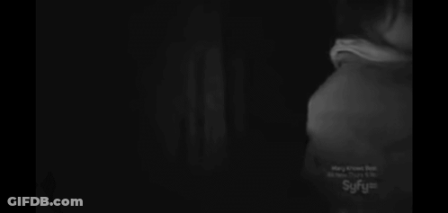 A Woman Is Taking A Picture With A Camera In The Dark GIF
