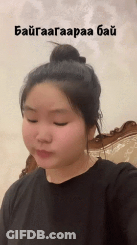 A Woman Is Taking A Selfie With A Bun In Her Hair And The Words " Baigaaagaraaa Bai " Written Above Her Head GIF