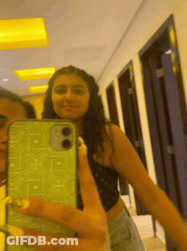A Woman Is Taking A Selfie With Her Phone GIF