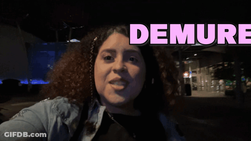 A Woman Is Taking A Selfie With The Words Demure Behind Her GIF