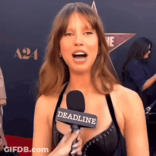 A Woman Is Talking Into A Microphone With The Word Deadline On It GIF