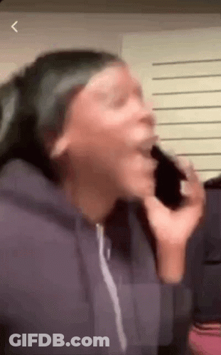 A Woman Is Talking On A Cell Phone And Making A Face . GIF