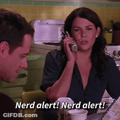 A Woman Is Talking On A Cell Phone While A Man Looks On And Says Nerd Alert ! Nerd Alert ! GIF