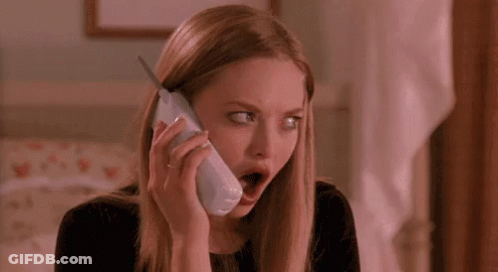 A Woman Is Talking On A Cell Phone With Her Mouth Open And Making A Surprised Face . GIF