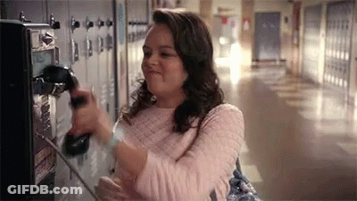 A Woman Is Talking On A Payphone In A Hallway . GIF