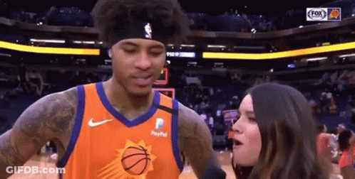 A Woman Is Talking To A Basketball Player Who Is Wearing A Paypal Jersey . GIF