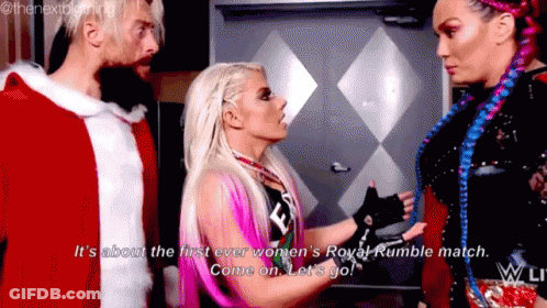 A Woman Is Talking To A Man And Another Woman While Wearing A Santa Claus Outfit . GIF