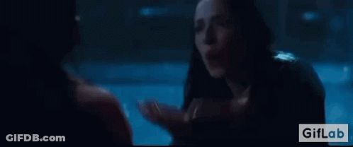 A Woman Is Talking To A Man In A Dark Room In A Movie . GIF