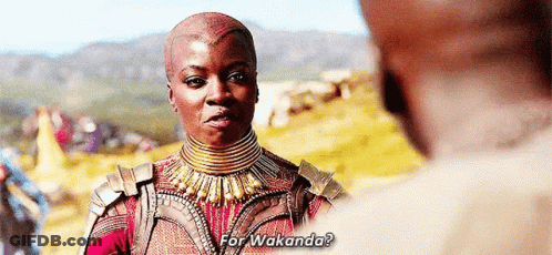A Woman Is Talking To A Man In A Field While Wearing A Necklace And Armor . GIF