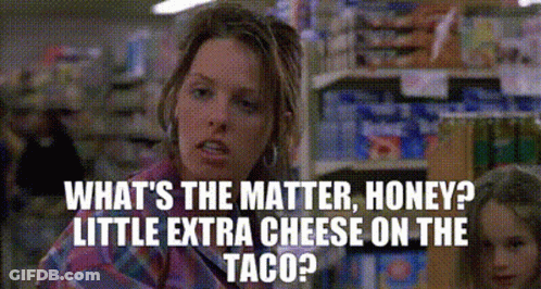 A Woman Is Talking To Another Woman In A Grocery Store While Holding A Taco . GIF