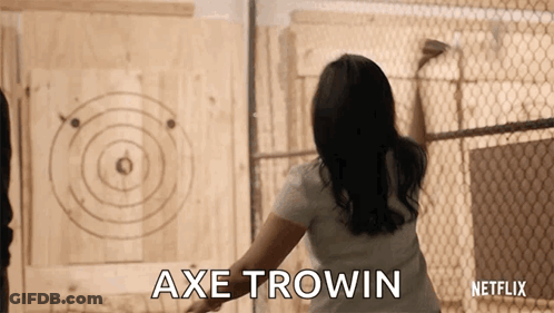 A Woman Is Throwing An Axe At A Target And The Words Axe Trowin Are On The Screen GIF