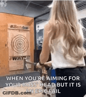 A Woman Is Throwing An Axe At A Target In A Room . GIF