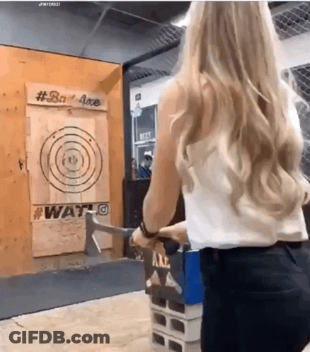 A Woman Is Throwing An Axe At A Target That Says #Bad Axe GIF