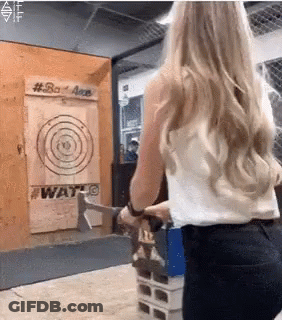 A Woman Is Throwing An Axe At A Target That Says #Bad Axe GIF