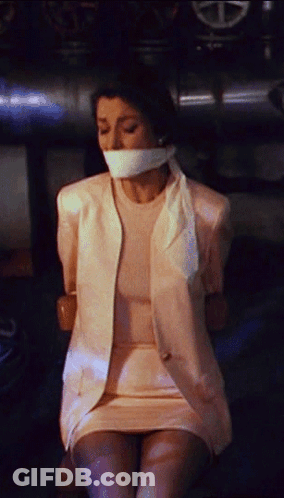 A Woman Is Tied Up With Duct Tape And Has A White Shirt On GIF