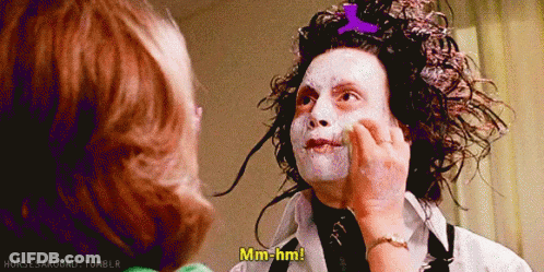 A Woman Is Touching A Man 'S Face And He Says Mm-Hmm GIF