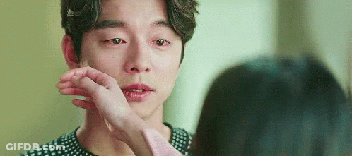 A Woman Is Touching A Man 'S Face With Her Hand While He Is Crying . GIF