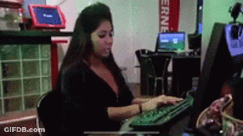A Woman Is Typing On A Computer Keyboard In Front Of A Sign That Says " Erne " GIF