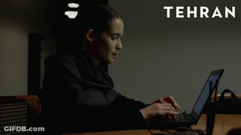 A Woman Is Typing On A Laptop With Tehran In White Letters GIF