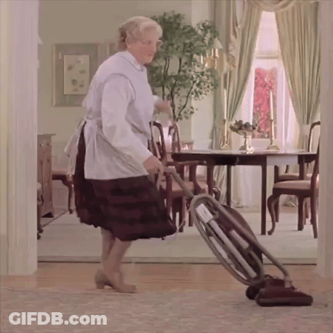 A Woman Is Using A Vacuum Cleaner To Clean The Floor In A Living Room GIF