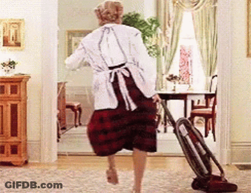 A Woman Is Using A Vacuum Cleaner To Clean The Floor In A Living Room GIF