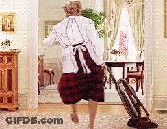 A Woman Is Using A Vacuum Cleaner To Clean The Floor In A Living Room GIF